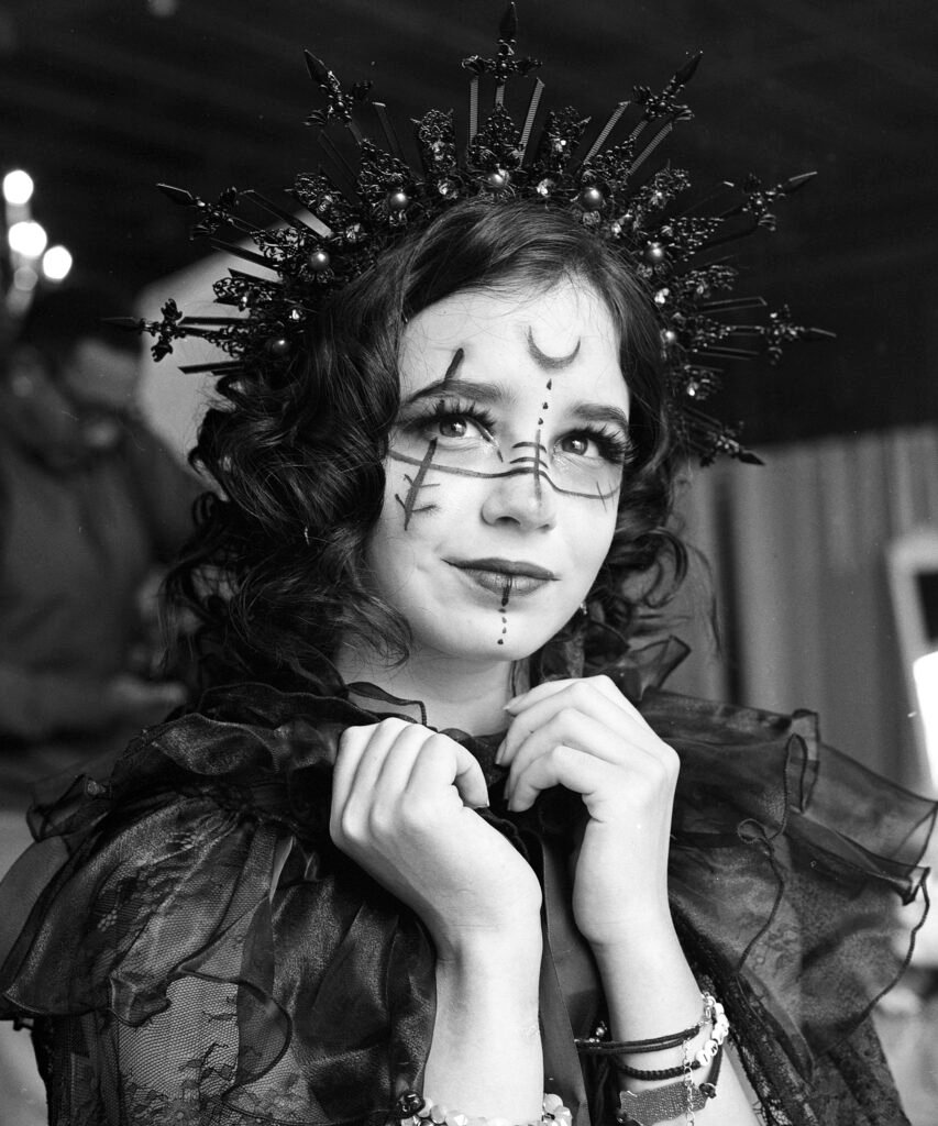 Lovely medium format black and white portrait of woman with face paint and crown in lace.