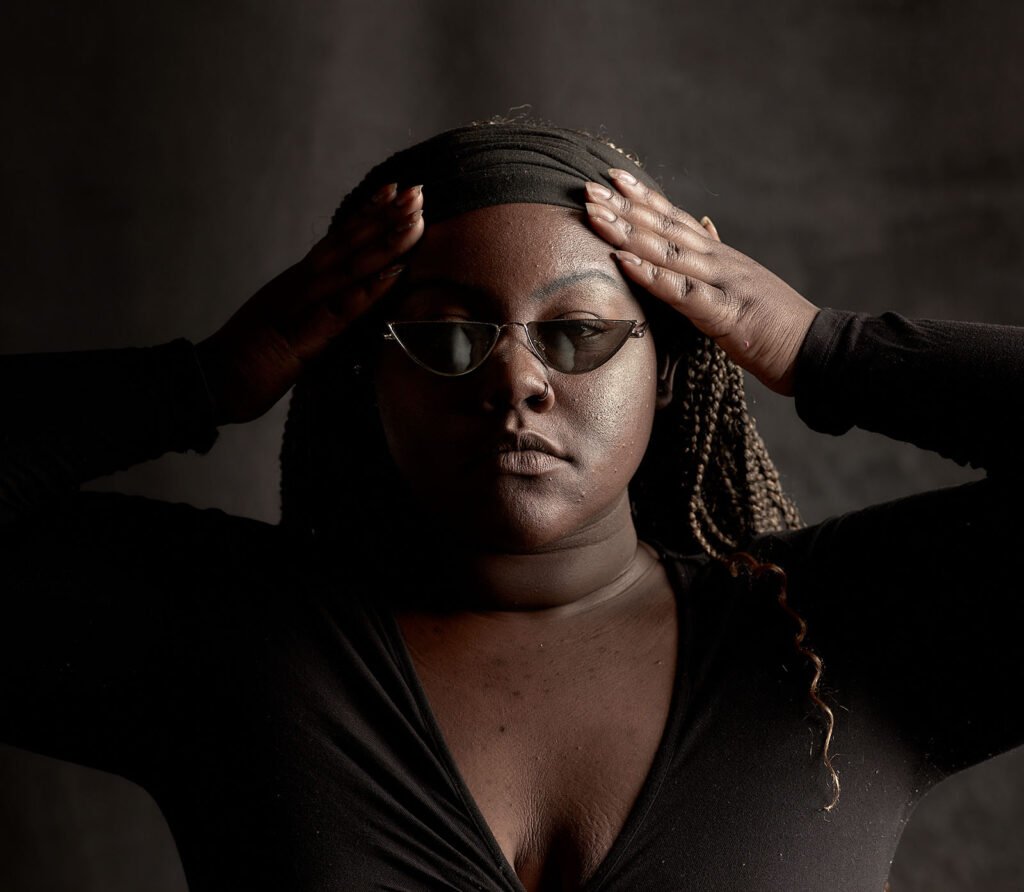 the gorgeous angelina hamm black woman model in studio with dark moody light and shades photo in studio.
