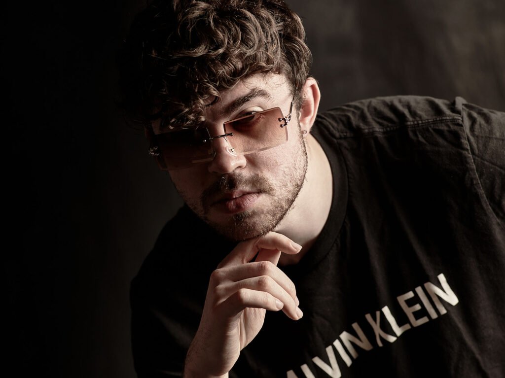 close up portrait of man with shades in t shirt with moody light.